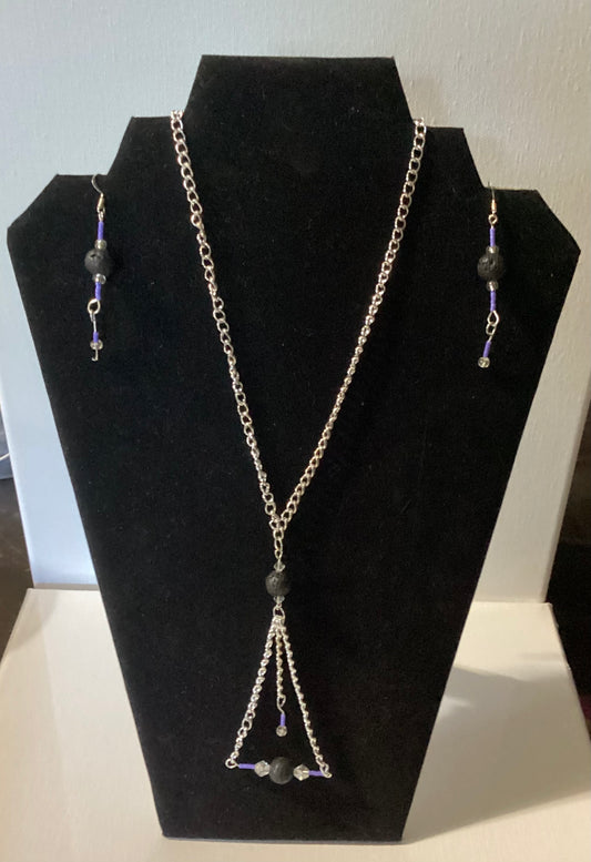 Necklace and earrings set on a black display stand with a white background