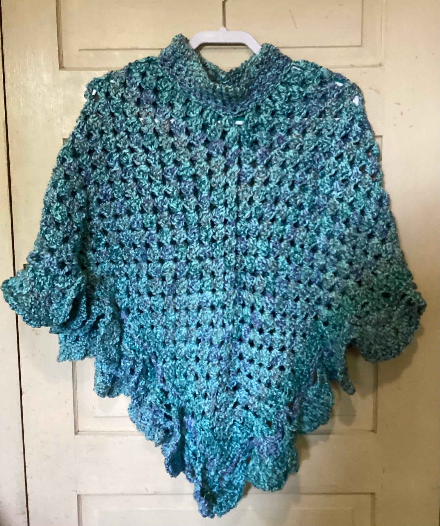 Crocheted poncho in shades of blue.